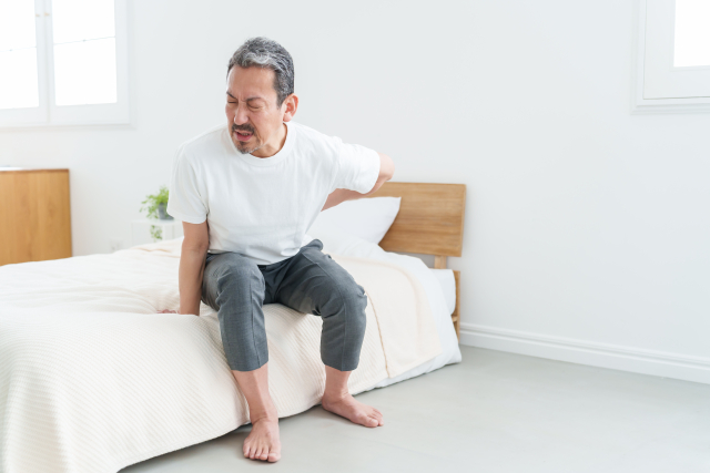 腰痛で起き上がるのがしんどい男性
